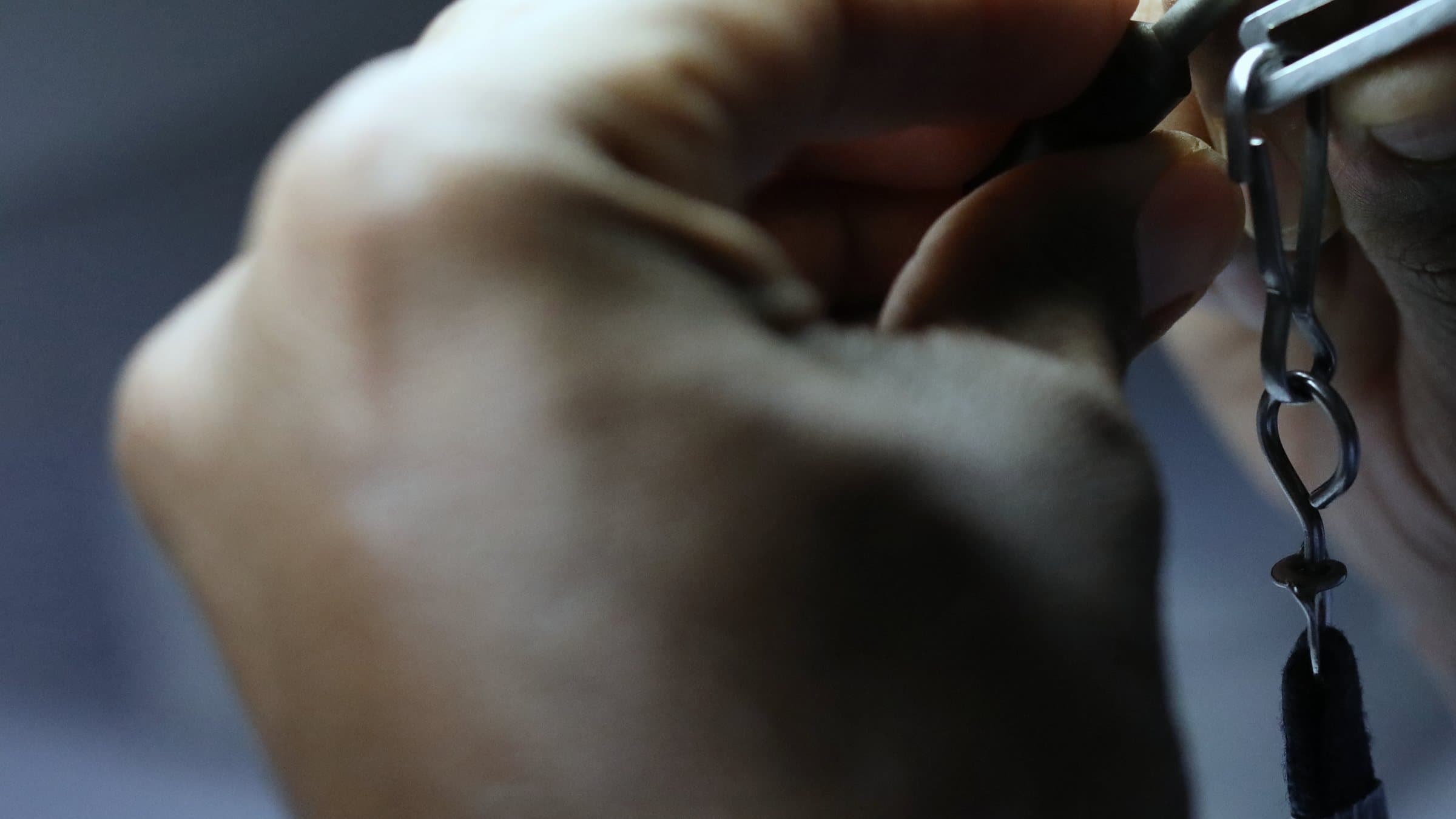 A stone held in tweezers for inspection